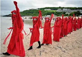  ?? GETTY ?? Extinction Rebellion (XR) Red Rebels activists take part in the Sound The Alarm march during the G7 summit in St Ives.