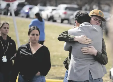  ?? AP PHOTO/DAVID ZALUBOWSKI ?? A student (right) hugs a parent as they are reunited following a shooting at East High School, on Wednesday in Denver.