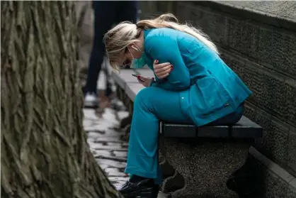  ?? Photograph: Jeenah Moon/Reuters ?? A healthcare worker sits on a bench near Central park in Manhattan.