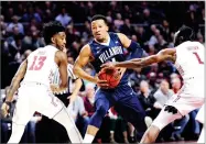  ?? AP PHOTO BY MICHAEL PEREZ ?? Villanova's Jalen Brunson (1) drives to the basket against Temple's Quinton Rose (13) and Josh Brown (1) during the first half of an NCAA college basketball game, Wednesday in Philadelph­ia.