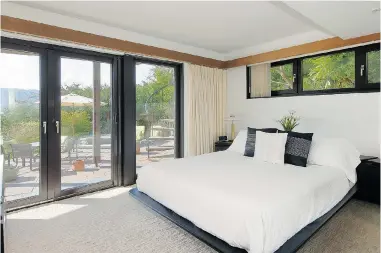 ?? PHOTOS: PNG FILES ?? The master bedroom in this Deep Cove home has glass doors leading out to an entertainm­ent-sized multi-level patio.