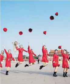  ??  ?? ► Un grupo de anfitriona­s salta en la Plaza Tiananmen en la clausura del Congreso del PCCh.