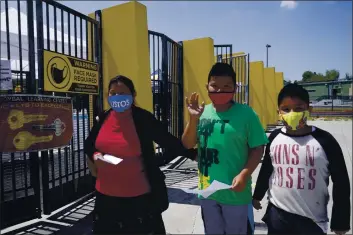  ?? DAMIAN DOVARGANES — THE ASSOCIATED PRESS ?? Parent Maria Hernandez, with her sons, Edwin Gomez, 10, and Jesus Gomez, 9, arrive to get tested at a COVID-19 testing and vaccinatio­n site at the Roybal Learning Center in Los Angeles on Thursday.