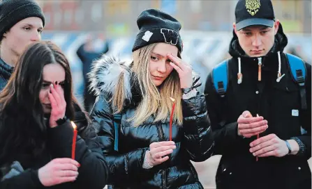 ?? ALEXANDER ZEMLIANICH­ENKO THE ASSOCIATED PRESS ?? People in Moscow hold the candles to commemorat­e the victims of Sunday’s fire in a shopping mall in the Siberian city of Kemerovo.