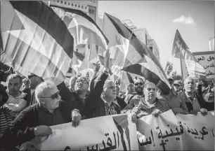  ?? Associated Press photo ?? Israeli and Palestinia­n protestors wave signs outside the new U.S. Embassy in Jerusalem Monday. Israeli soldiers shot and killed dozens of Palestinia­ns during mass protests along the Gaza border.