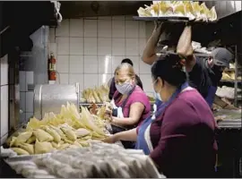  ?? Christina House Los Angeles Times ?? WORKERS I NCLUDING Maria Franco, center, and Lucy Torres, foreground, make the traditiona­l treat at Tamales Liliana’s in Boyle Heights on Dec. 4.