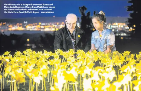  ?? BRIAN MORRISON ?? Gary Hunter, who is living with a terminal illness and Marie Curie Registered Nurse Tracy McWilliams among the illuminate­d daffodils at Belfast Castle to launch the Marie Curie Great Daffodil Appeal