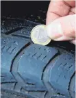  ??  ?? Billiger Trick: Mit einer Euromünze lässt sich prüfen, ob die Reifen noch genug Profil haben.