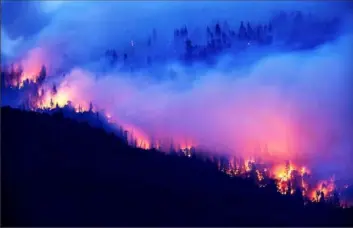  ?? Noah Berger/ Associated Press ?? The Creek Fire burns along a hillside in the Cascadel Woods community of Madera County, Calif., on Monday.