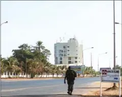  ?? STRINGER/AFP ?? A member of the military walks along an empty street in Serrekunda west of Banjul, as Gambian President Yahya Jammeh’s mandate expired yesterday.