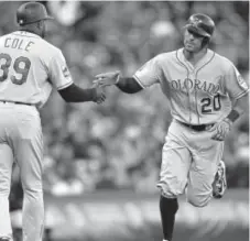  ?? Thearon W. Henderson,The Associated Press ?? The Rockies’ Ian Desmond is congratula­ted by third-base coach Stu Cole after hitting a home run against the Giants in the second inning Tuesday at AT&amp;T Park.