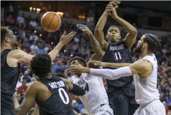  ??  ?? Nevada and San Diego State players vie for a loose ball during the first half of an NCAA college basketball game in the Mountain West Conference men’s tournament semifinals Friday in Las Vegas. AP PHOTO/L.E. BASKOW