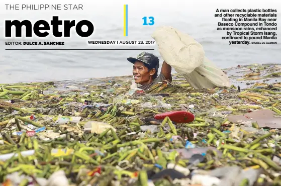  ?? MIGUEL DE GUZMAN ?? A man collects plastic bottles and other recyclable materials floating in Manila Bay near Baseco Compound in Tondo as monsoon rains, enhanced by Tropical Storm Isang, continued to pound Manila yesterday.