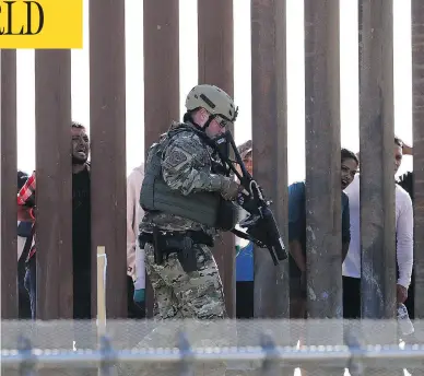  ?? GREG BULL / THE ASSOCIATED PRESS ?? A U.S. Customs and Border Protection officer walks along a barrier at the Mexico-U.S. border, in San Diego, Calif., on Sunday. Migrants attempted to penetrate several points along the border.
