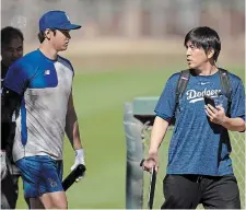 ?? CAROLYN KASTER THE ASSOCIATED PRESS FILE PHOTO ?? Shohei Ohtani, left, walks with interprete­r Ippei Mizuhara at batting practice during spring training in Phoenix. Mizuhara has been fired by the Dodgers following allegation­s of illegal gambling and theft.