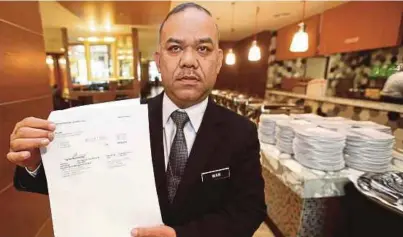  ?? [FOTO MOHAMAD SHAHRIL BADRI SAALI/BH] ?? Wan Abdullah menunjukka­n invois harga bagi makanan tengah hari pada Majlis Angkat Sumpah dan Persidanga­n Parlimen
Ke-14 di Dewan Rakyat, di Kuala Lumpur, semalam.