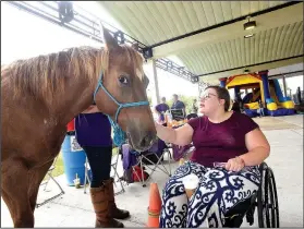  ?? NWA Democrat-Gazette/FLIP PUTTHOFF ?? Tabitha Mayberry of Springdale gets acquainted Saturday at Mindfest NWA with Rain, a horse from Courage Theraputic Riding Center in Prairie Grove.