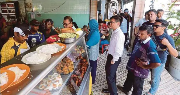  ??  ?? Customers queuing for a plate of Nasi Vanggey, which is made up of rice, fried chicken, salted egg and vegetables.