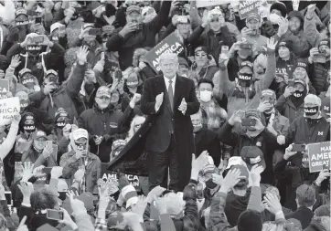  ?? CARLOS OSORIO AP ?? President Donald Trump arrives at a campaign rally Saturday in Norton Shores, Michigan, surrounded by thousands of supporters, despite polls that continue to show him lagging behind Democratic nominee Joe Biden.