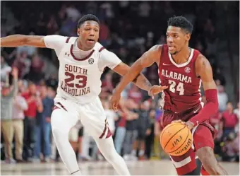  ?? AP PHOTO/SEAN RAYFORD ?? Alabama freshman Brandon Miller dribbles past South Carolina forward Gregory Jackson II on the way to scoring a go-ahead basket in overtime Wednesday night in Columbia, S.C.