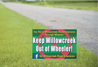  ?? MICHAEL GARD/POST-TRIBUNE ?? A sign along County Road 650 West in Wheeler opposes the extension of Willowcree­k Road through the town.