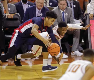  ?? Associated Press ?? Mississipp­i guard Breein Tyree, left, fights for a loose ball with Texas guard Kerwin Roach, right, during the first half of an NCAA college basketball game Saturday in Austin.