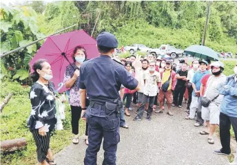  ??  ?? A policeman gives instructio­ns to applicants outside the Pakan police station yesterday.