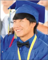  ?? Photo by Mike Eckels ?? Leng Lee watched his portion of the senior photo presentati­on during the 2017 Decatur High School graduation ceremony. The presentati­on showcased a few photos of Lee during his school years.