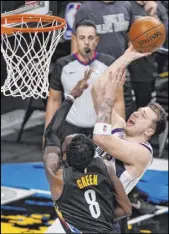  ?? John Minchillo The Associated Press ?? Mavericks guard Luka Doncic lines up a shot against Nets forward Jeff Green in the second half of Dallas’ 115-98 win Saturday at Barclays Center.