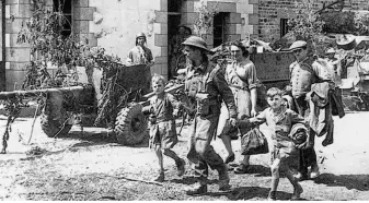  ??  ?? Un soldat britanniqu­e de la 8 th Rifle Brigade accompagne des enfants à Saint-Martin-des-Besaces.