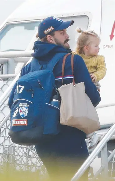  ??  ?? Josh Bruce of the Bulldogs and daughter Poppy board a flight from Melbourne to the Gold Coast yesterday; and (left) St Kilda’s Zak Jones should be fit. Main picture: Getty