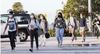  ?? CARL JUSTE cjuste@miamiheral­d.com ?? MAST Academy students walk toward campus off the Rickenback­er Causeway as all elementary students plus students in grades 6, 9 and 10 return for in-person learning on Wednesday.