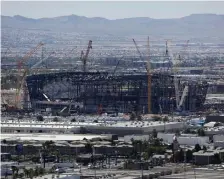  ??  ?? GOING UP: Constructi­on cranes surround a football stadium under constructi­on in Las Vegas.