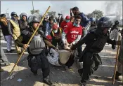  ?? ANJUM NAVEED / ASSOCIATED PRESS ?? Police officers carry an injured protester during a clash in Islamabad, Pakistan, on Saturday, during a second day of widespread Islamist unrest.