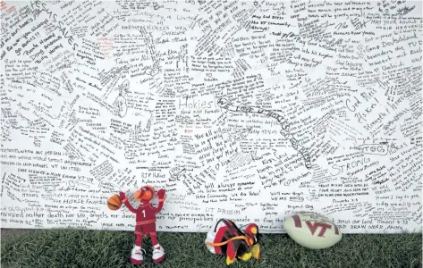  ?? ALEX BRANDON/THE ASSOCIATED PRESS ?? A memorial board sits under a tent with items that were placed in front of it, on the Drillfield on the Virginia Tech campus in Blacksburg, Va. Ten years after a mentally ill student fatally shot 32 people at Virginia Tech, survivors and families of...