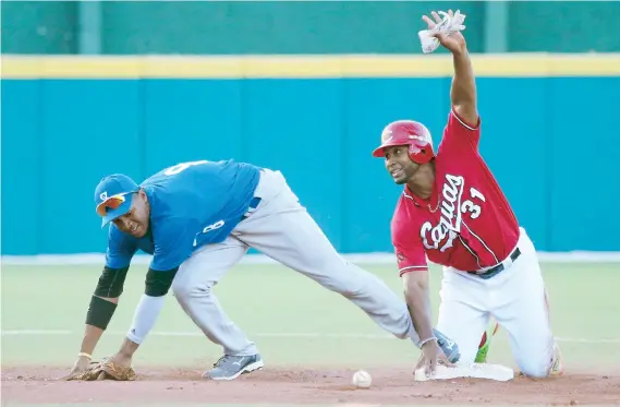  ??  ?? Jorge Padilla, de Caguas, pide tiempo luego de arribar a la segunda base en el partido del domingo. Abiatal Avelino no puede retener la bola.