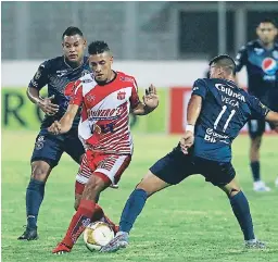  ??  ?? Fuerza. Marco Vega intenta quitarle la pelota al jugador del Vida Deni Meléndez.