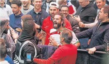  ?? ?? GOAL: Security calms things down as a man celebrates Iran scoring at London fanzone.