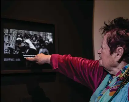  ??  ?? Holocaust survivor from Auschwitz concentrat­ion camp Kriegel Grossman points at herself shown in a video from Auschwitz camp at the opening of "Flashes of Memory" exhibition of the photos and videos from the Holocaust