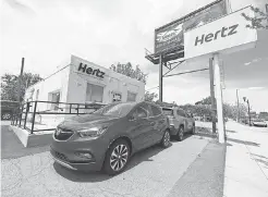 ??  ?? Rental vehicles are parked outside a closed Hertz car rental office in south Denver in May. DAVID ZALUBOWSKI/ AP