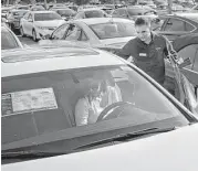  ?? Scott McIntyre / New York Times ?? A salesman helps a customer at a Carmax dealership in Doral, Fla. The U.S. gross domestic product grew at an annual rate of 0.7 percent in the first quarter.