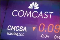  ?? (AP) ?? In this file photo, the symbol for Comcast appears on a screen at the Nasdaq MarketSite, in New York. The coronaviru­s pandemic took a toll on Comcast in the second quarter as movie theaters
closed, theme parks shut down and advertiser­s cut back.