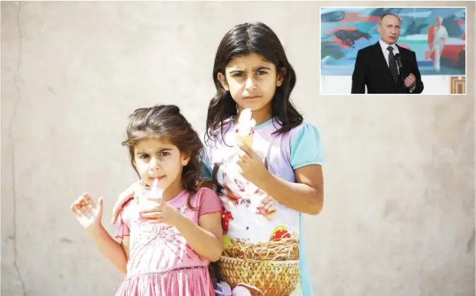  ?? — AFP ?? Syrian girls pose for a photograph as they stand on a street in the Kurdish-majority northeaste­rn city of Qamishli on Friday. (Inset) Russian President Vladimir Putin speaks to journalist­s at an airport in Bishkek yesterday.