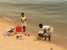  ??  ??  RINNANDE VATTEN. Mamma och dotter diskar och tvättar kläder på stranden i Monkey Bay.
 RUNT MUMBO. Rapha tar oss på en tur kring holmen i den varma skymningen.