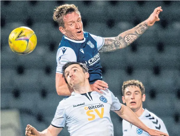  ??  ?? HEAD MAN: Dundee’s Lee Ashcroft wins an aerial duel against Michael Miller of Ayr United at Dens Park on Tuesday night.