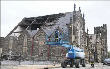  ?? SUE OGROCKI AP ?? Equipment is moved into place outside the New Life at Calvary Church on Friday in Cleveland after storms damaged the 143-year-old church building late Thursday.