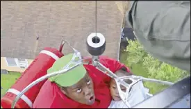  ?? REUTERS ?? A woman and her daughter are rescued by a Coast Guard helicopter after Hurricane Harvey flooded their neighborho­od in Beaumont, Texas on Tuesday.