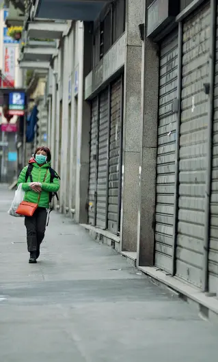  ??  ?? Serrande abbassate La prospettiv­a di una strada commercial­e milanese con i negozi chiusi