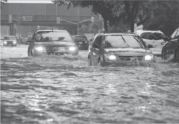  ?? JASON KRYK ?? Cars struggle down Dominion Boulevard in South Windsor on Tuesday after the city received up to 280 millimetre­s of rain in a 20-hour period.