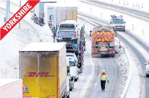  ??  ?? Gritting lorry nudges past stranded traffic to clear a lane of the A1 near Catterick